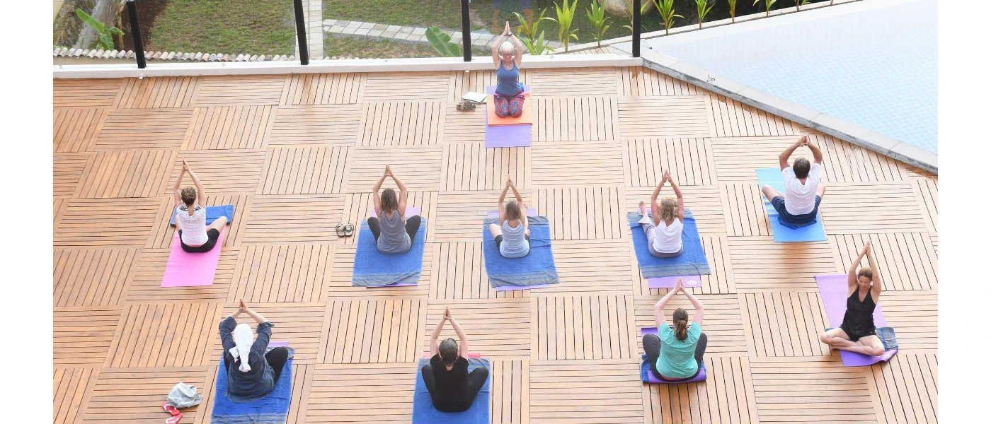 Group in active wear on blue mats in a yoga shala 
