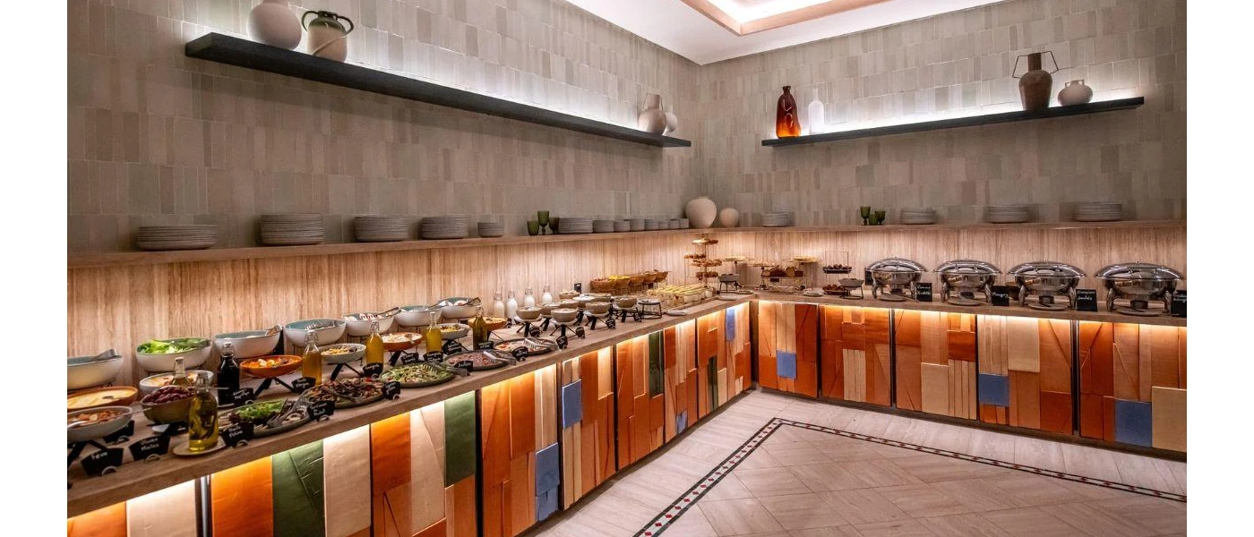 Food piled up along buffet stations with a colourful base and atmoshpheric lighting