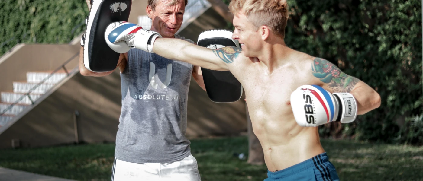 Two men boxing in a tropical garden