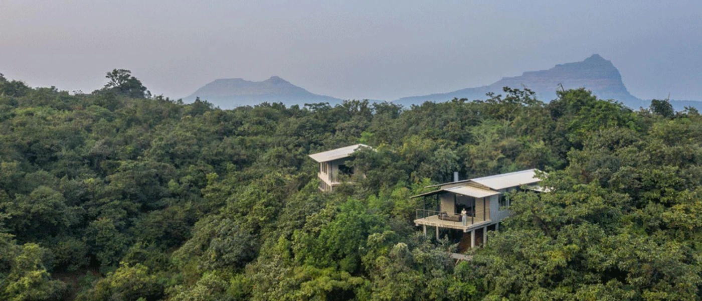Villas poke through the greenery among forested hills