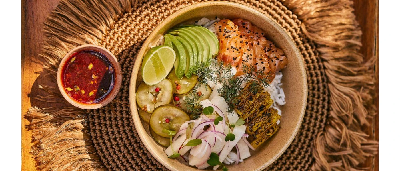 Poke bowl with avocado, salmon, rice and limes
