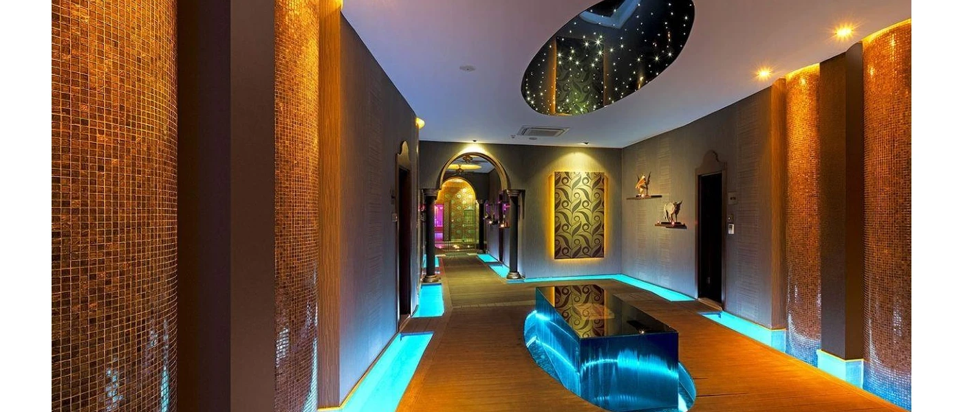 Spa with tiled walls, spotlights, a contemporary light feature with twinkling lights, blue LED lighting and Arabic-style archways