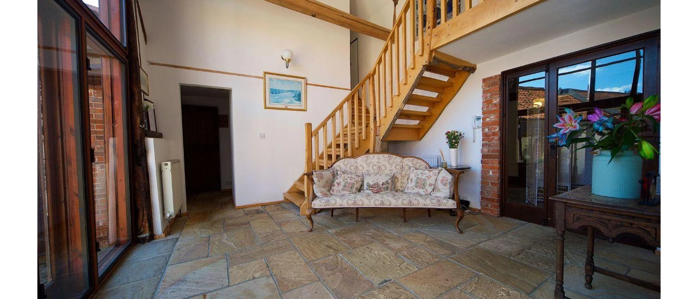 Traditional hallway with stone floors and a cosy sofa 