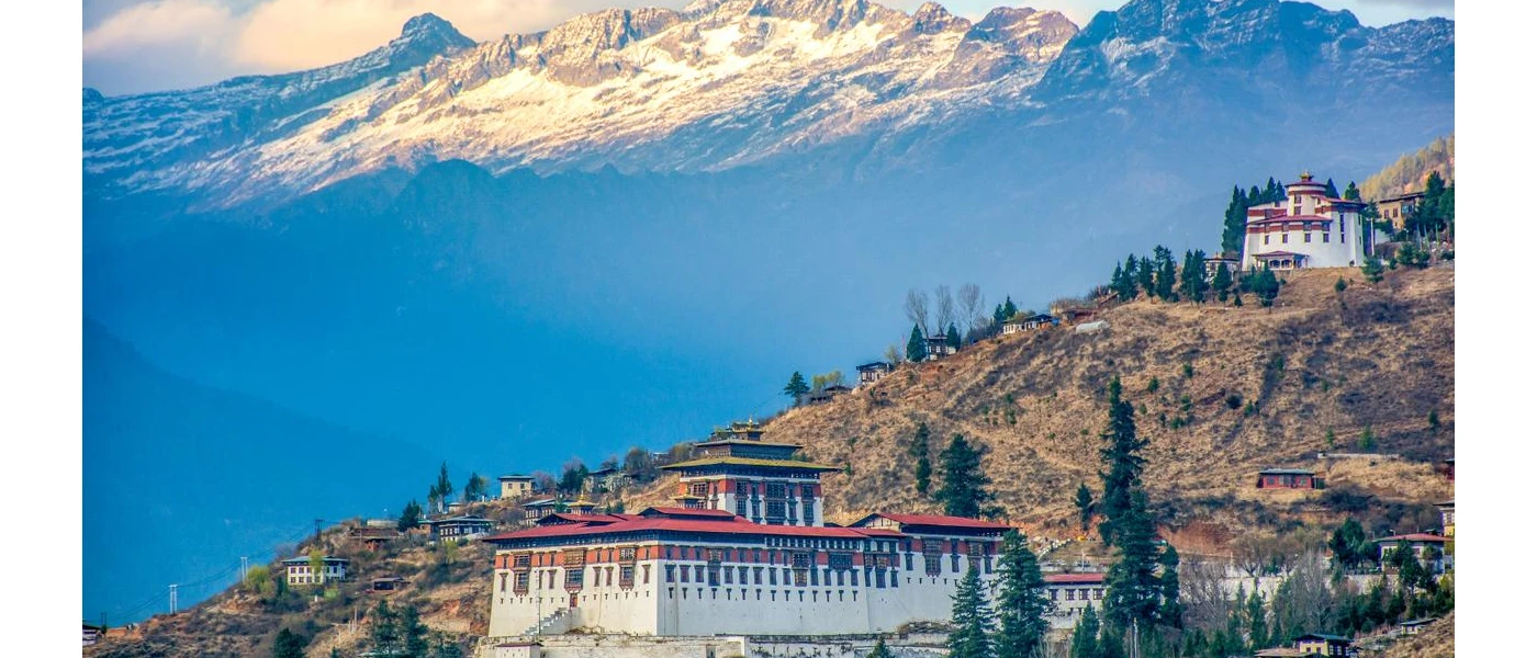 Red-roofed monasteries among snow-capped mountain peaks