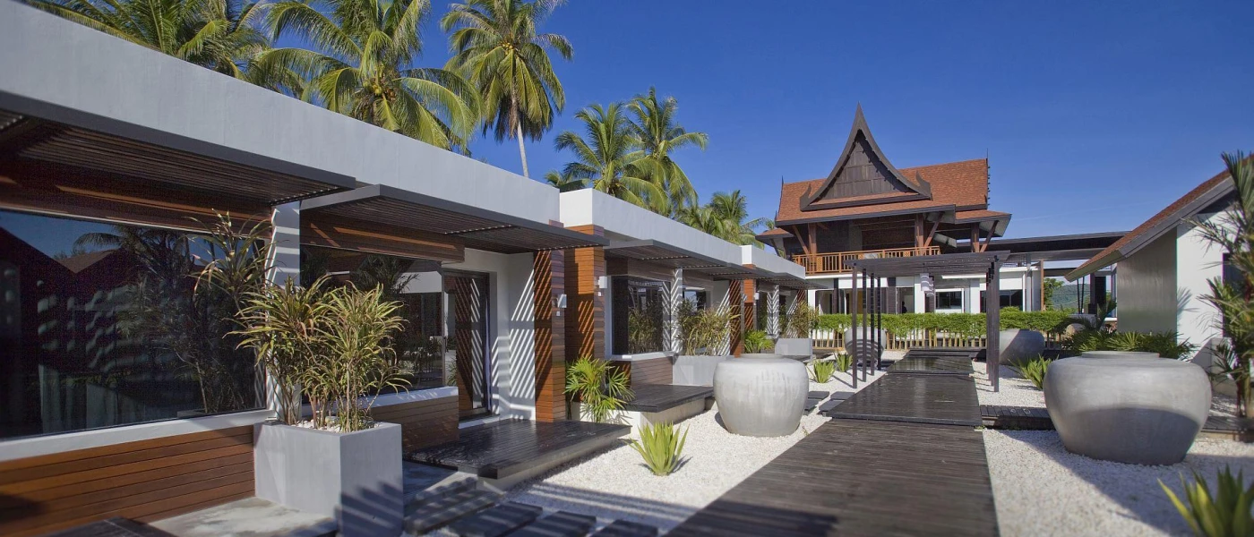 Low-rise buildings with a central wooden pathway, fronted by a temple-style building
