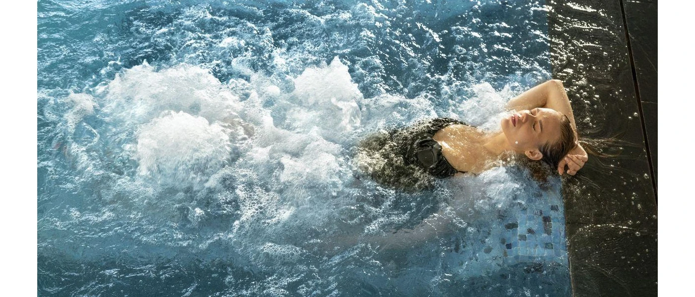 Woman relaxing in a swimming pool with under-water jets