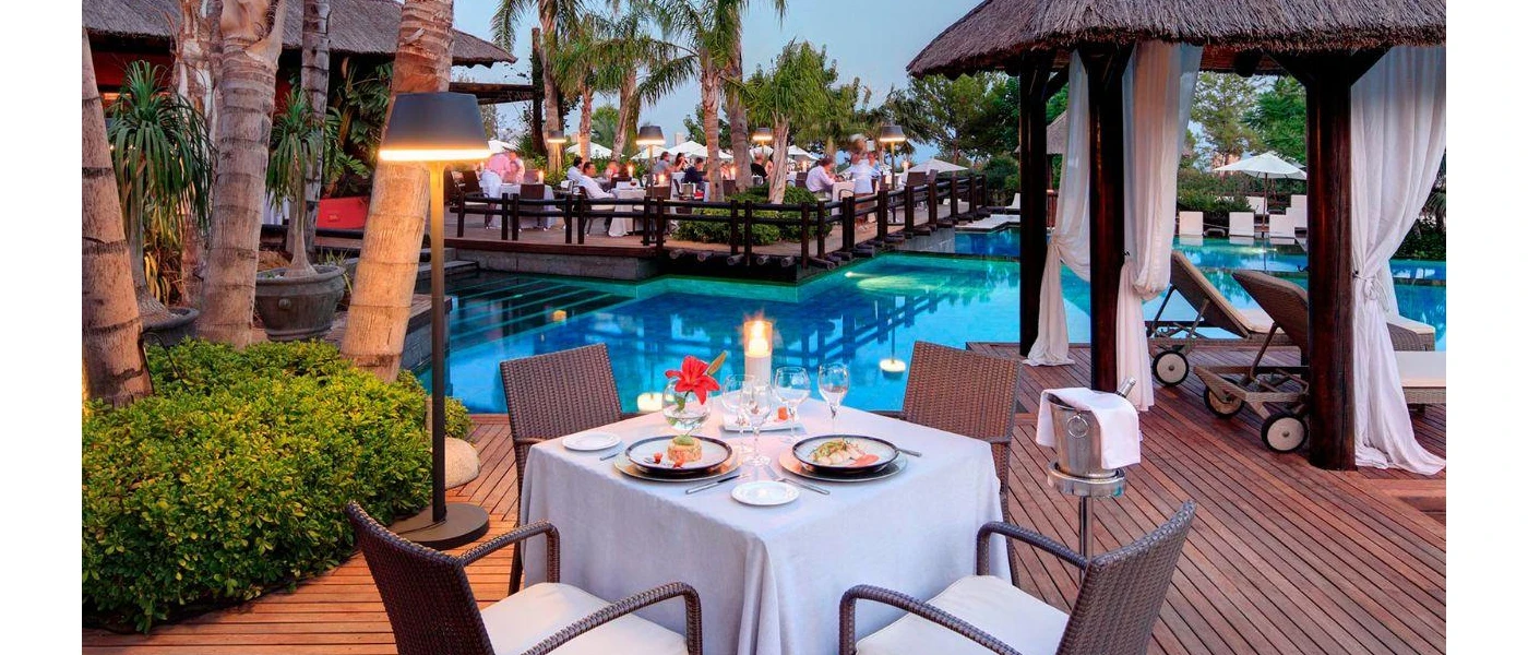 Poolside terraces laid up for dinner with white tablecloths