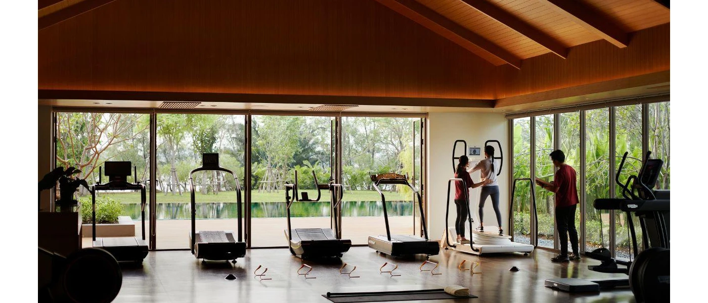 Gym with a row of treadmills and floor-to-ceiling windows 