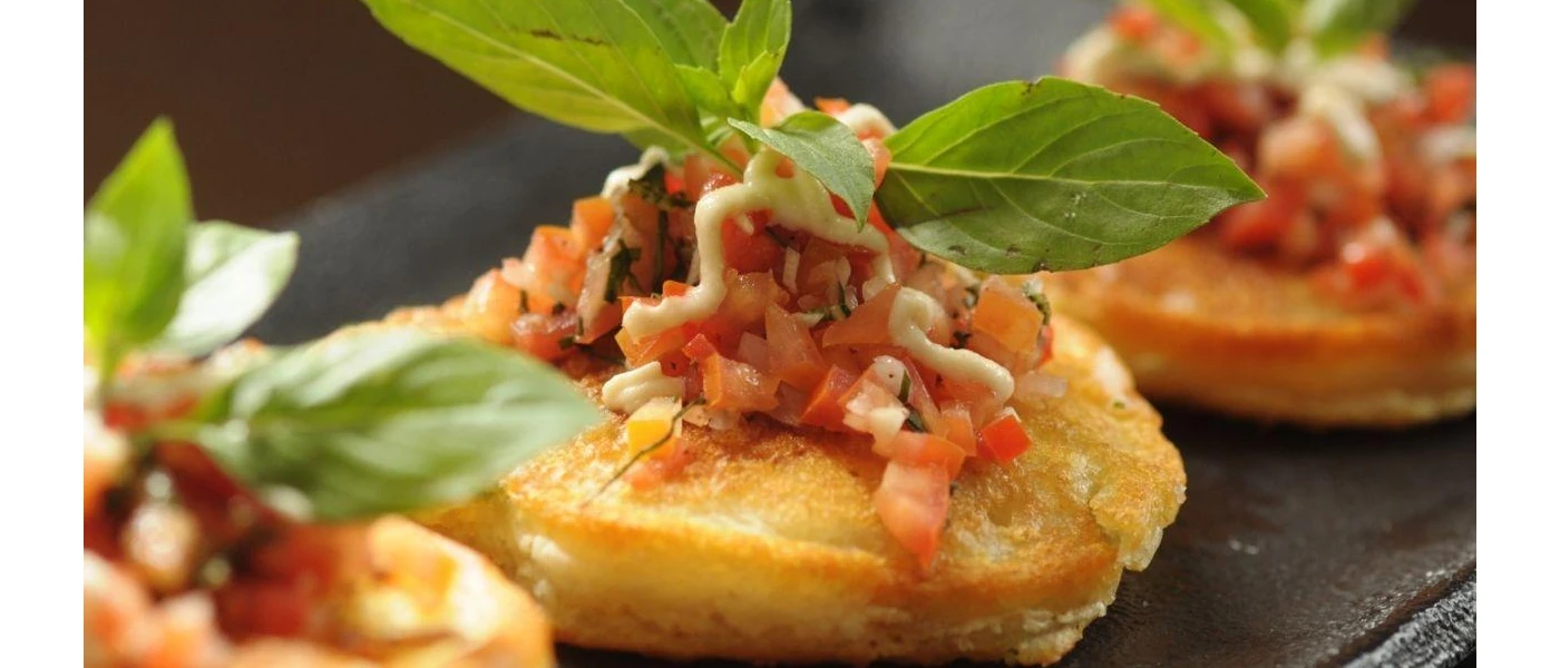 Crusty crostini topped with chopped tomatoes and a sprig of basil