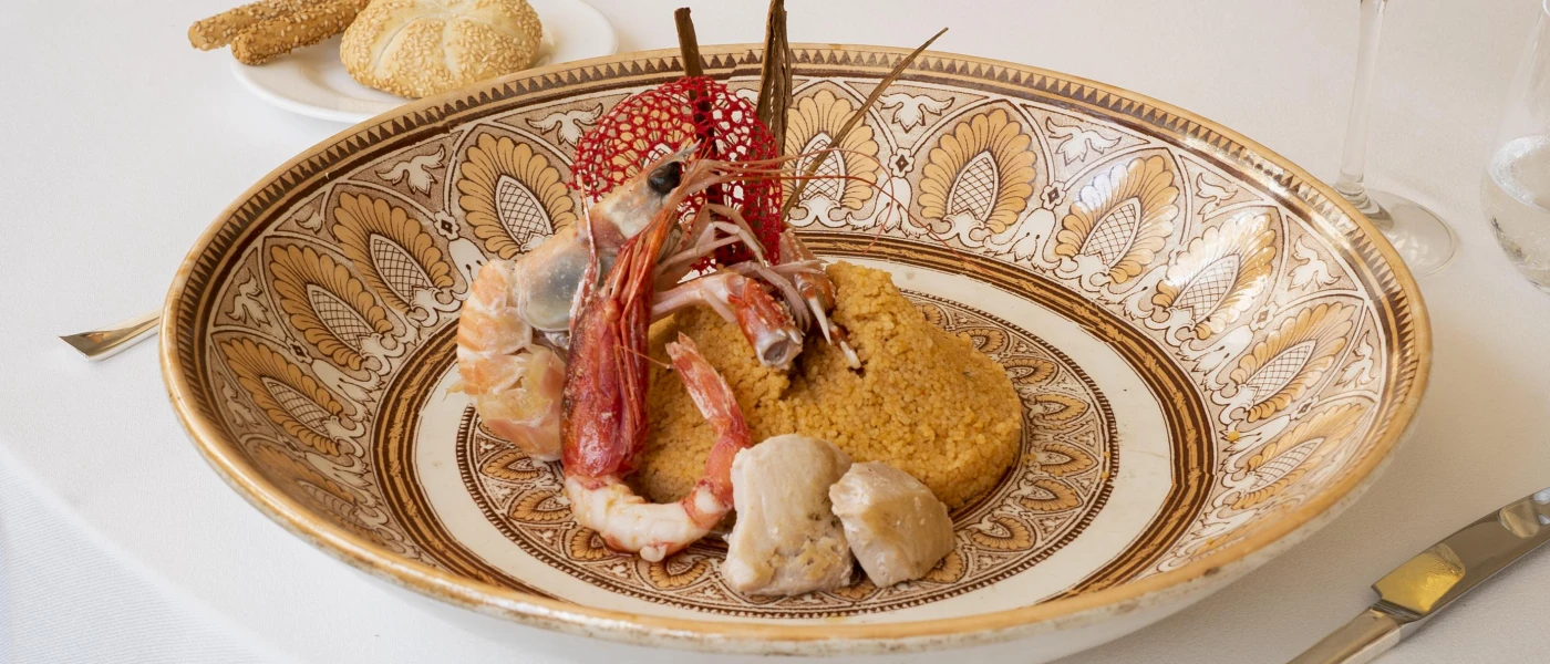 Patterned china bowl with a mound of cous cous and a prawn on the side
