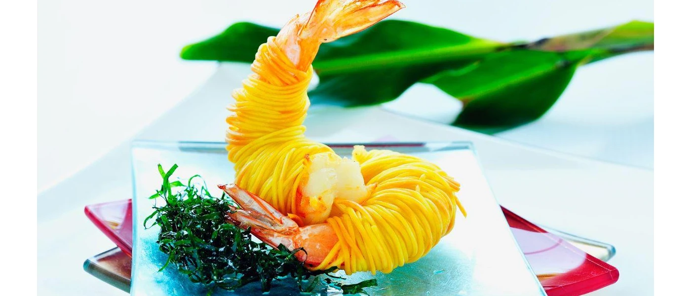 Two juicy looking prawns in a crispy coating laid out on a small white plate