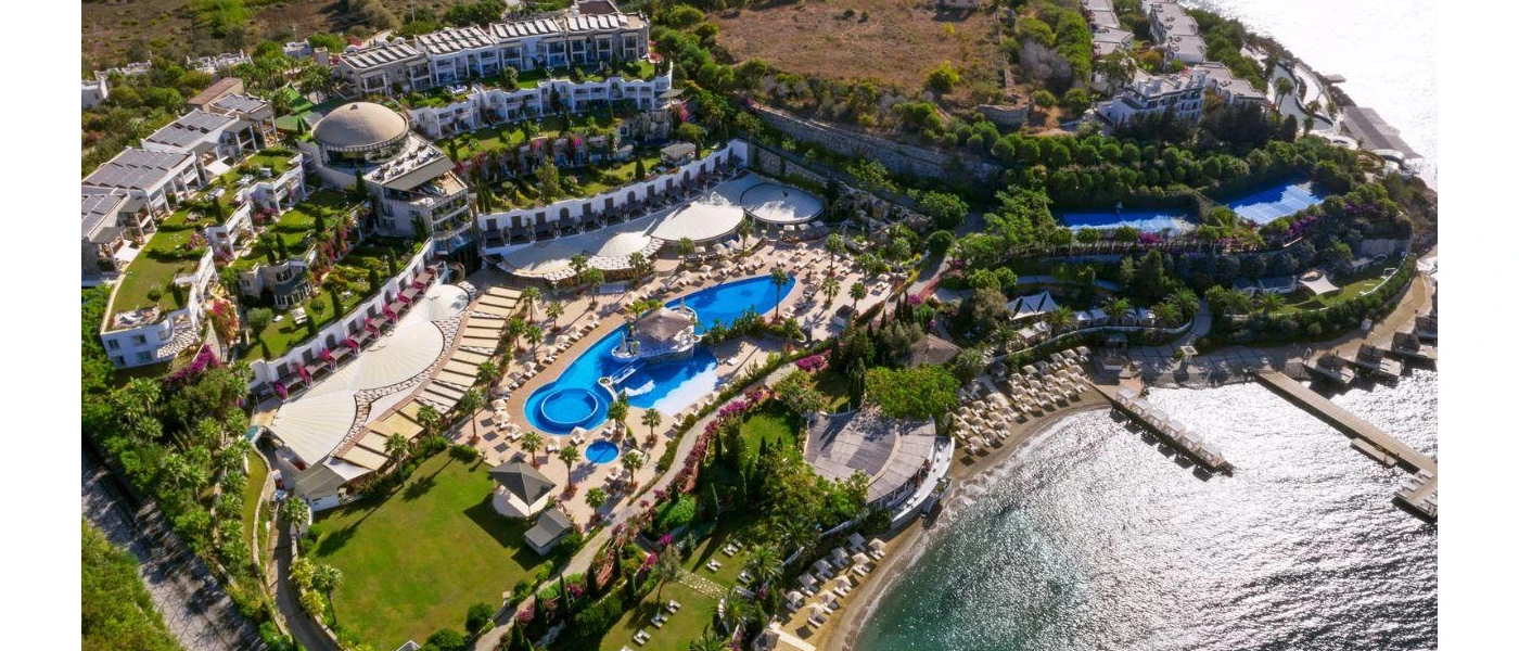 Whitewashed resort spread over a staggered tropical hillside overlooking the sea, with swimming pools, a sandy beach and jetties that jut out into the water