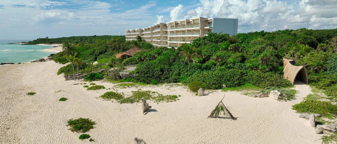Milky sands and mangroves in front of a white high-rise resort