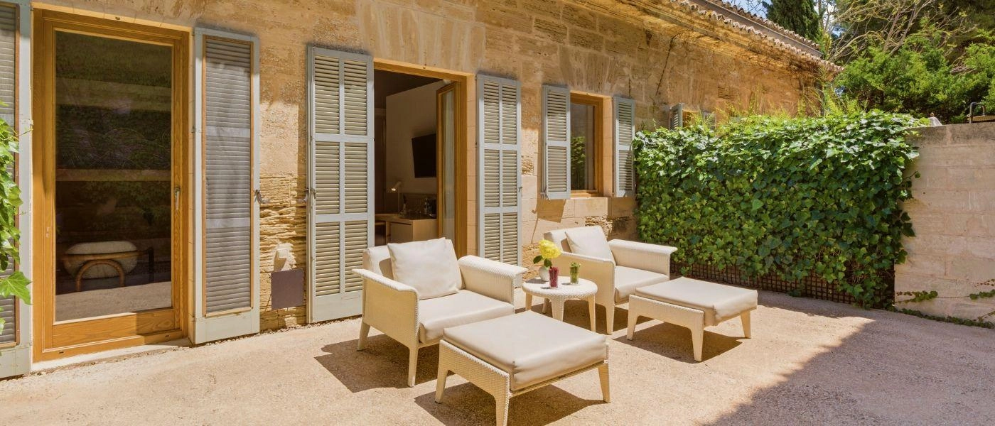 Outdoor terrace with white furniture and wall