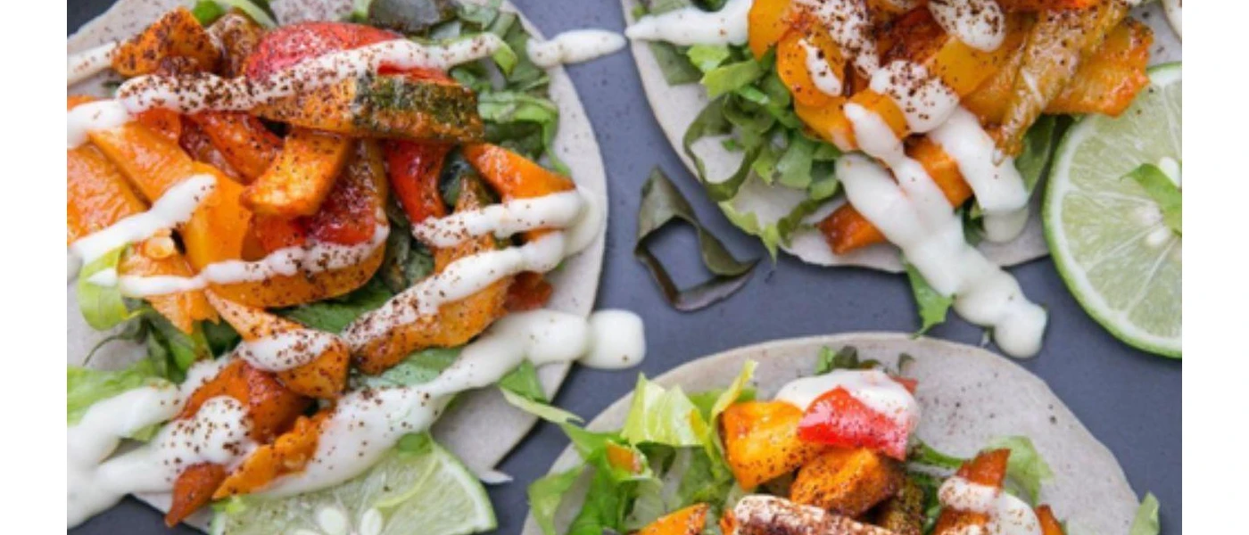 Tortilla wraps laid with vegetables and drizzled in a white sauce