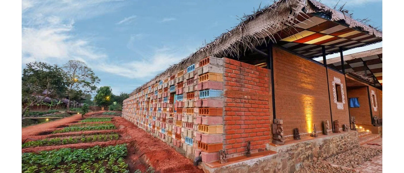 Stone-walled, orange thatched-roof building, next to an organic garden