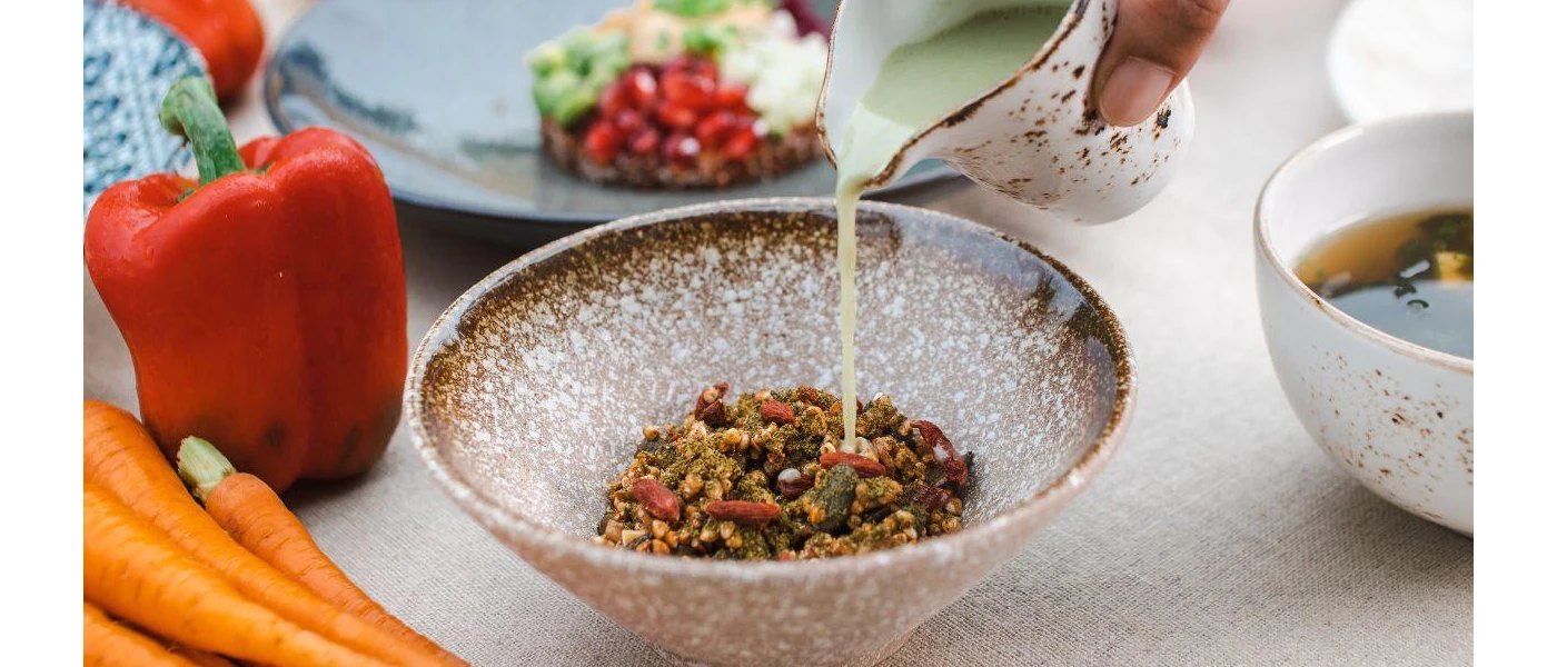 Bowl of healthy lookin grains as someone pours milk into it