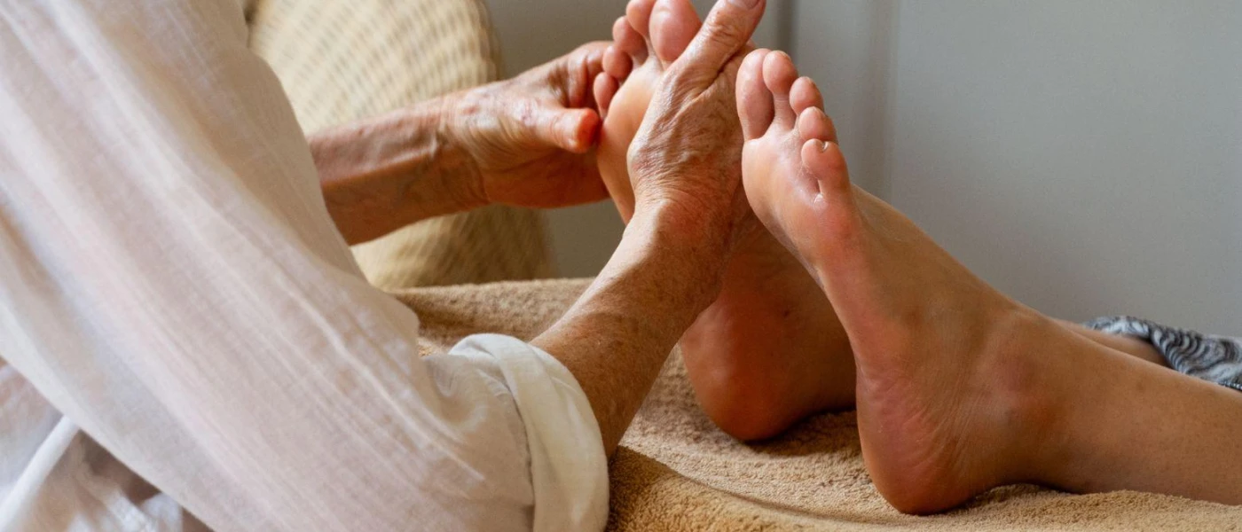 A person examining the feet of another person