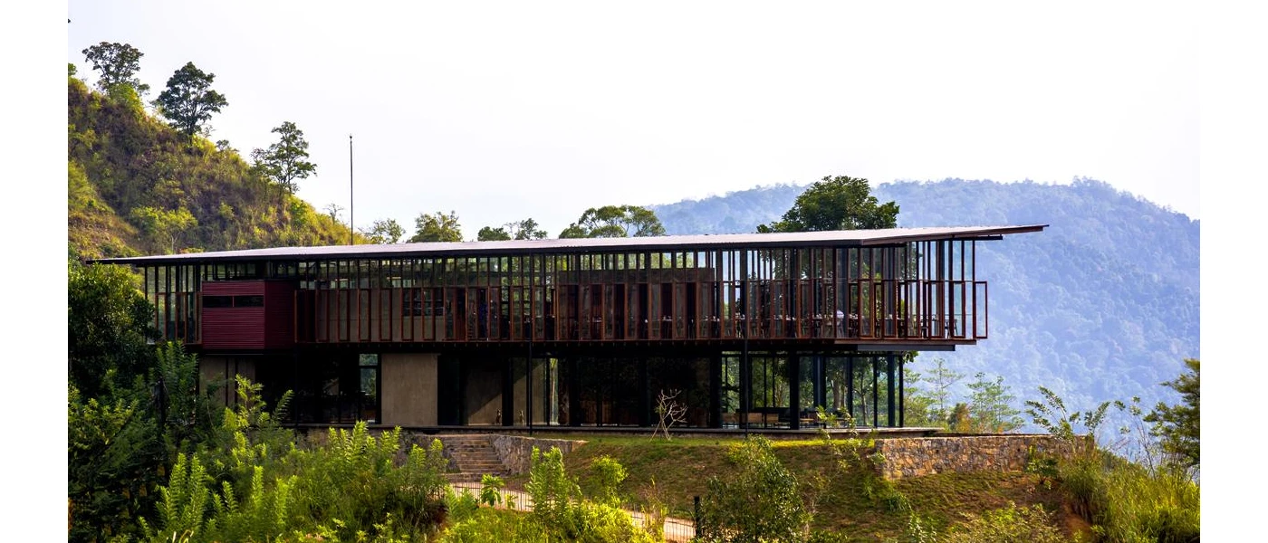 Minimalist restaurant on wooden stilts with panoramic glass windows