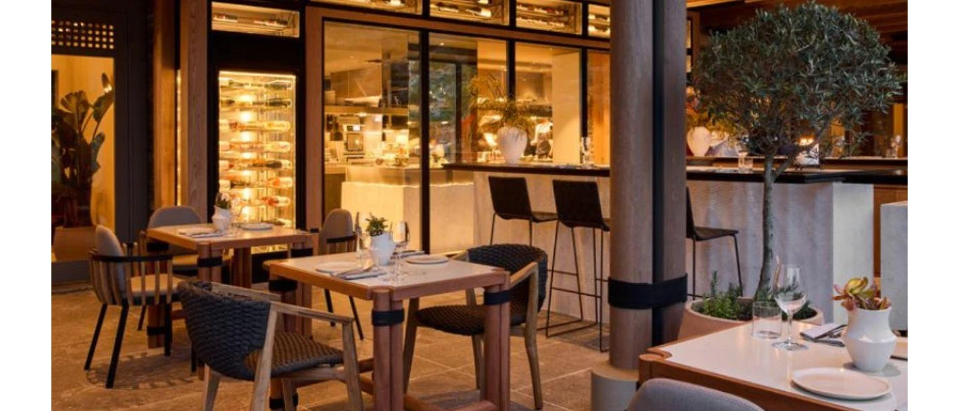 An outdoor dining space of RHO restaurant with bar and wine cellar at the back 