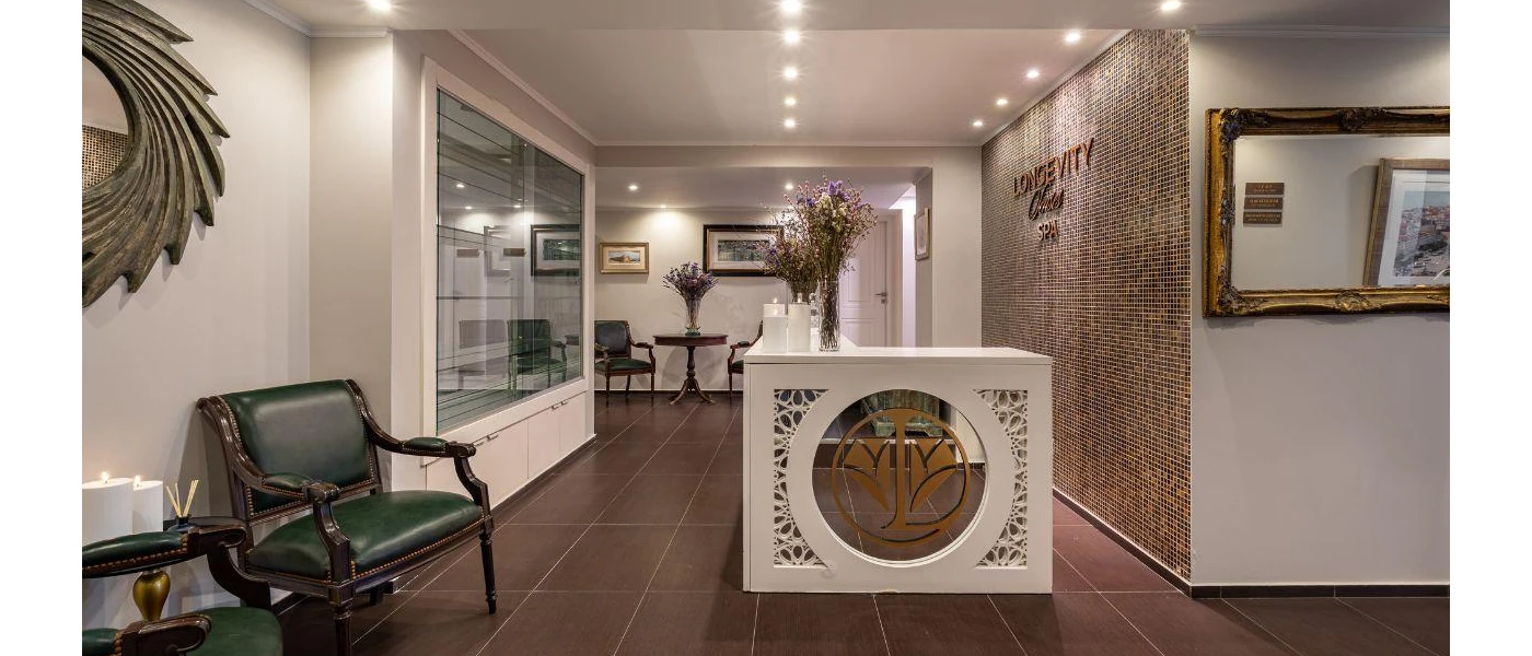 Entrance room with tiled walls, gold mirrors, vases of flowers and tiled floors