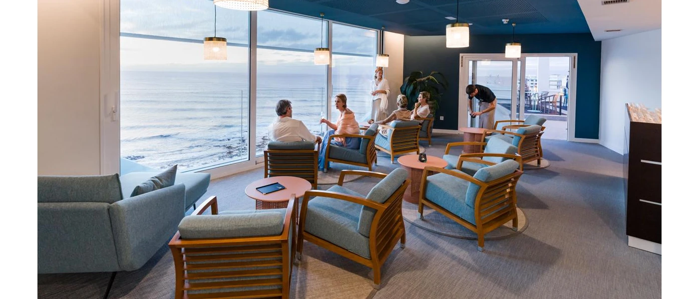 Guests sitting chatting while looking out to sea in a smart seating area