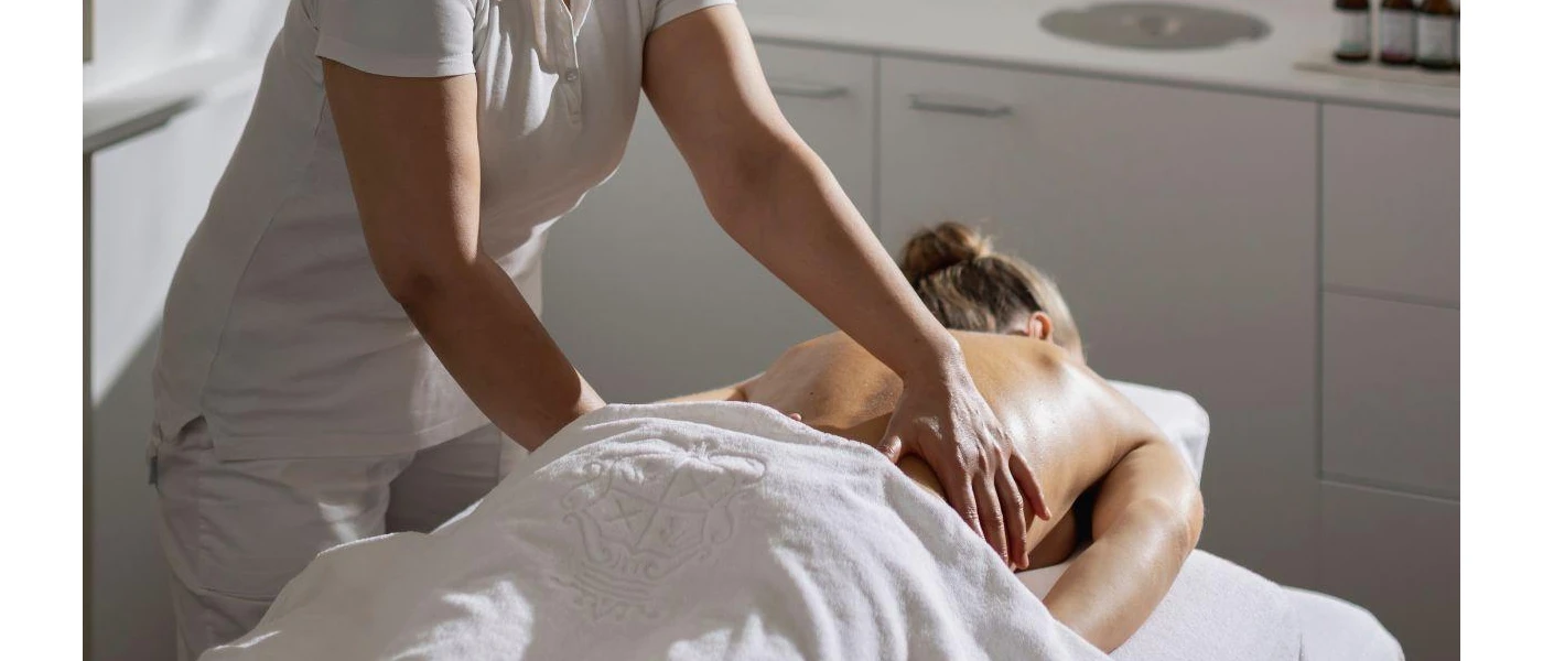 Female guest having a relaxing upper back massage in a treatment room with natural daylight 