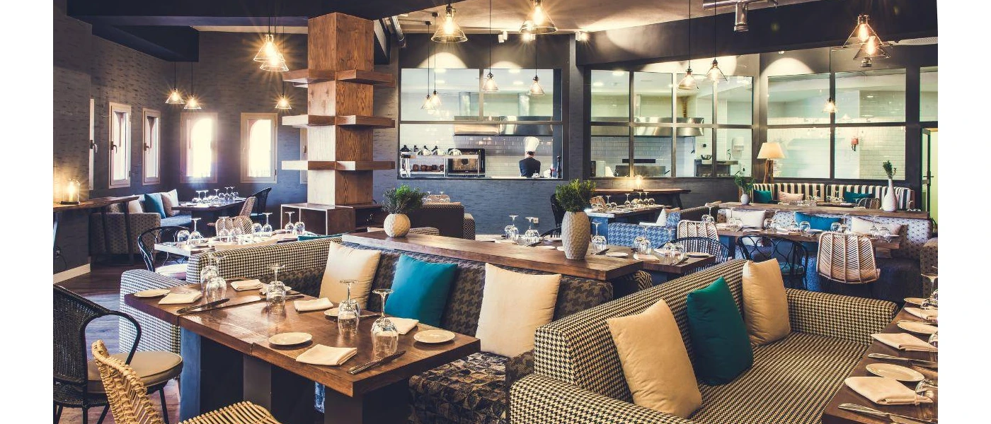 Bohemian-style restaurant with blue and yellow cushions, sofa seating and wooden tables