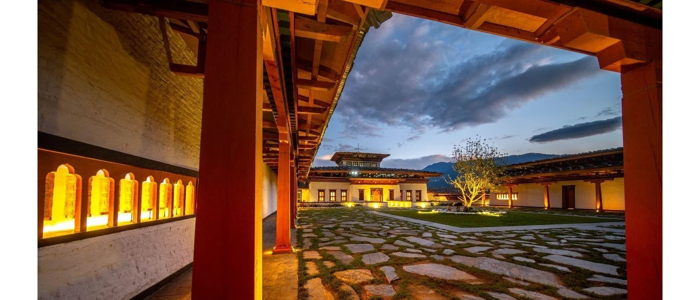 Cobbled courtyard in a monastery at twilight, as warm light pours from the inside