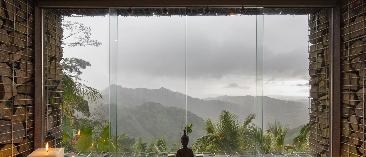 Candlelit room with a large window looking out towards cloudy mountain peaks