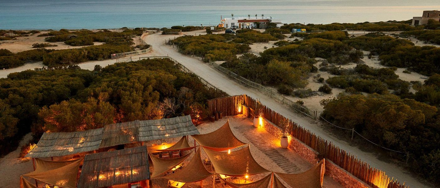 Pine forests and pathways lead down to the Mediterranean Sea, overlooked by a restaurant-bars softly lit and with rattan canopy roofing