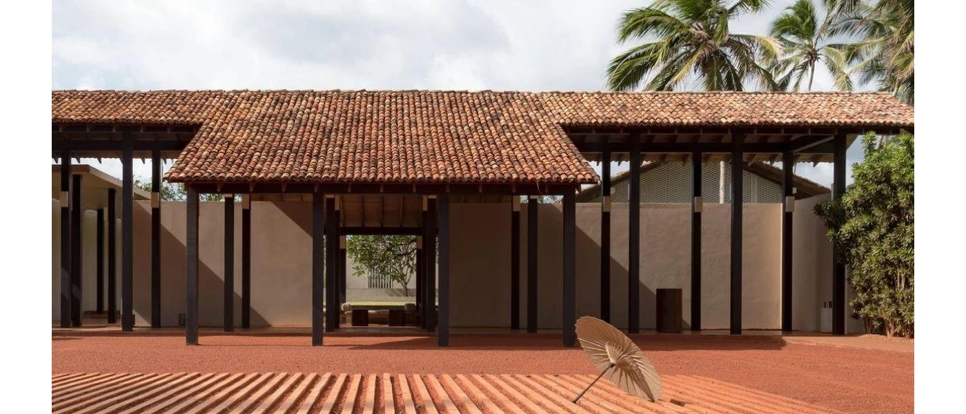 Red-roofed low-rise building with clean lines, fronted by a lone umbrella lying on its side
