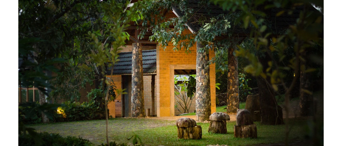 Yellow-painted building shrouded in greenery with sculptures out the front