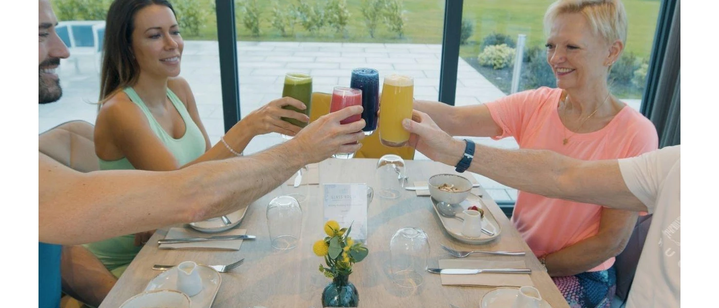 Group of people toasting smoothies over a white table