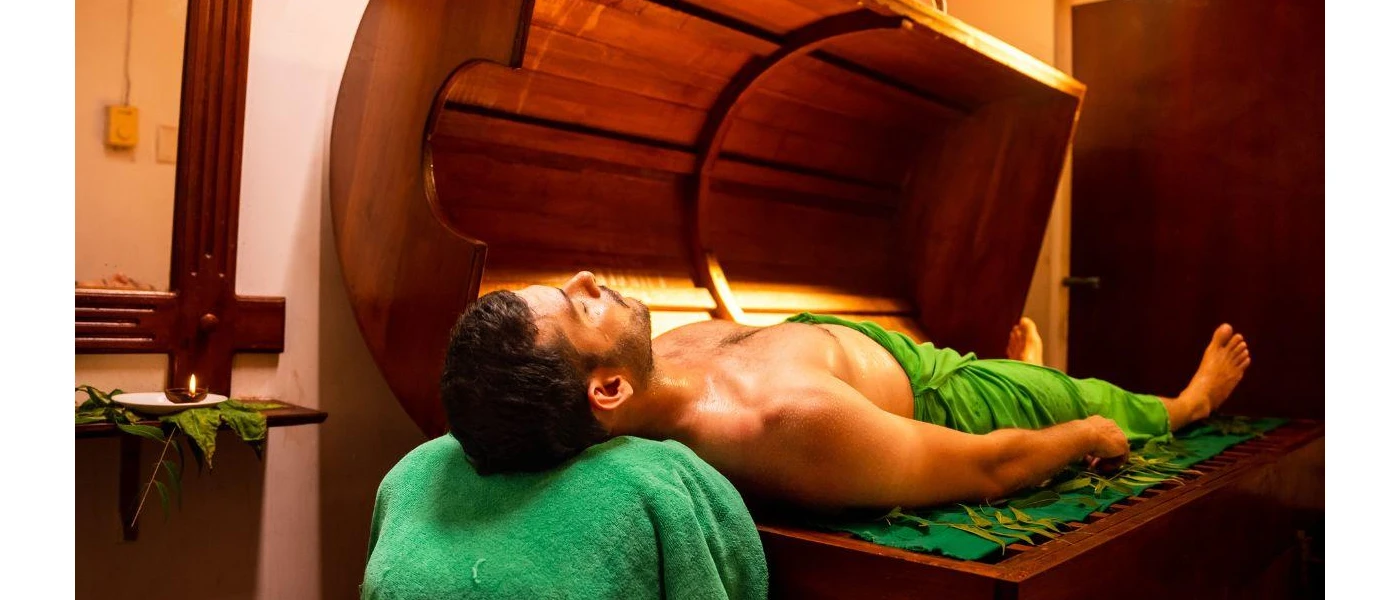 Man lies on his back on a wooden bed in a candlelit room