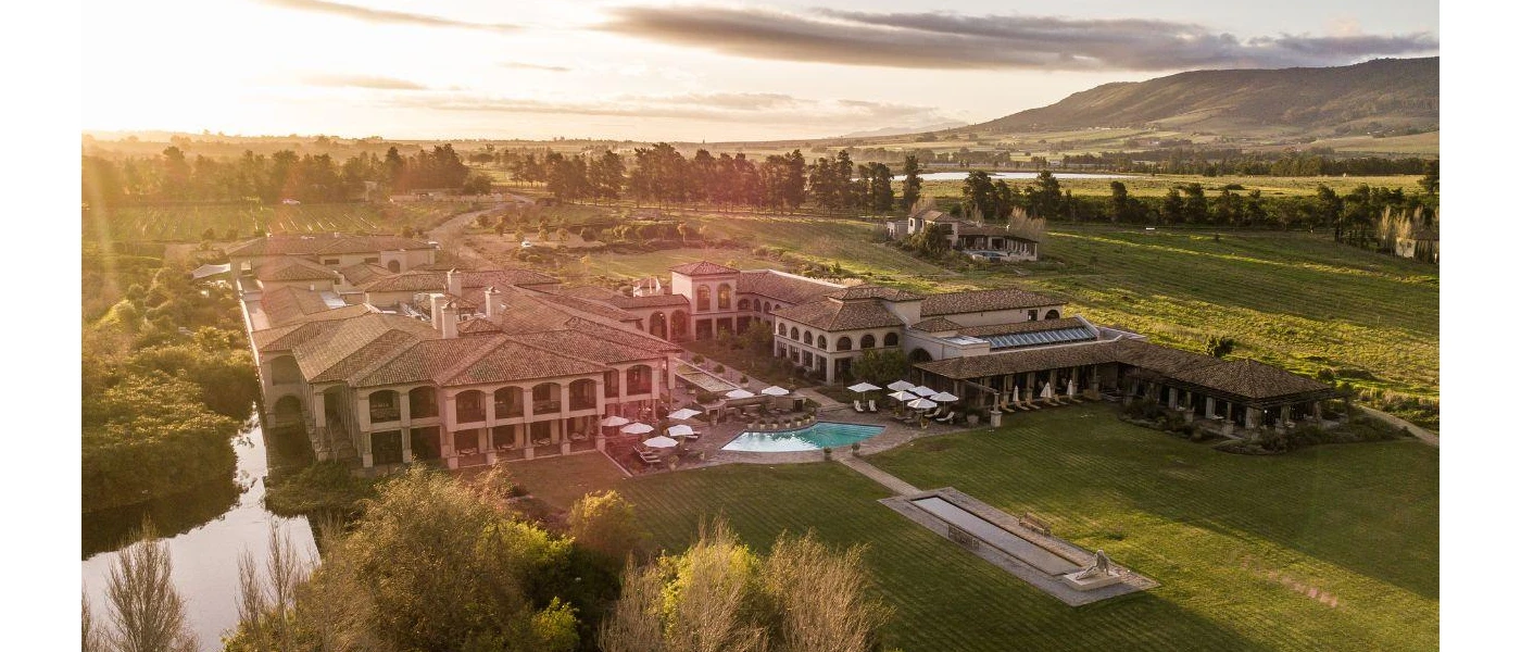 Aerial view of SANté Wellness Retreat & Spa, its two-storey sand-coloured buildings, outdoor pool and surrounding Winelands