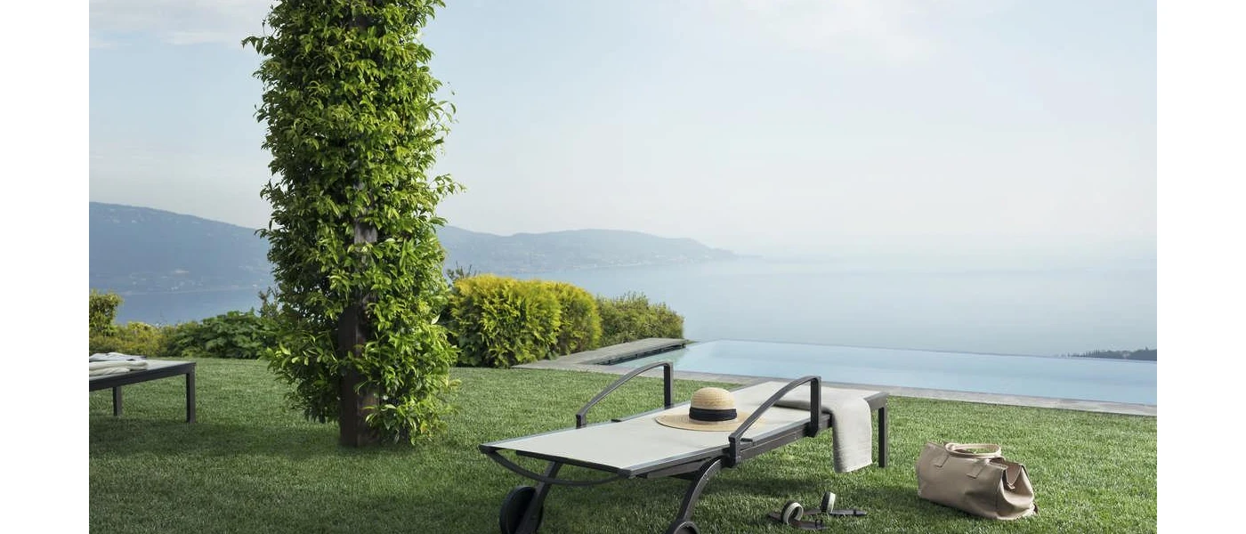 White lounger on a grassy lawn overlooking a misty lake and mountains