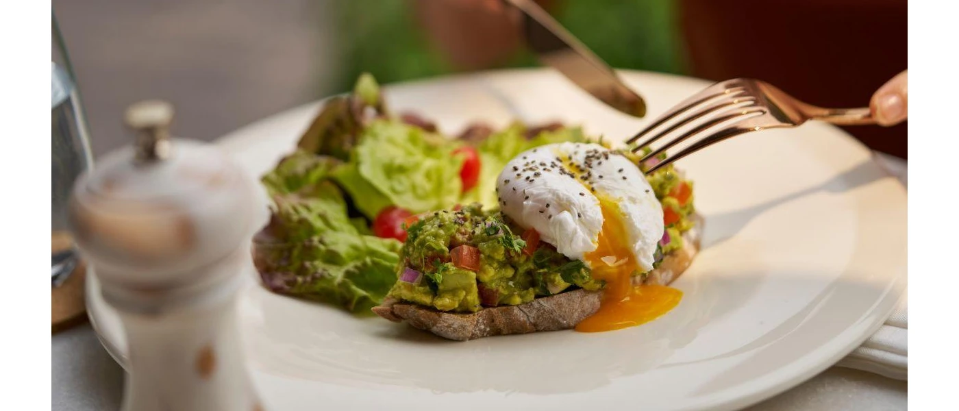Crusty bread topped with avocado, peppers, red onion and poached egg