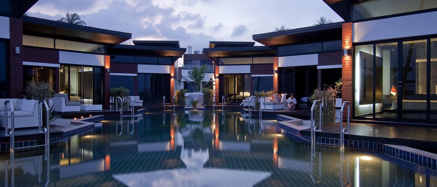 Low-rise contemporary villas huddled around a central pool with ladders into the water