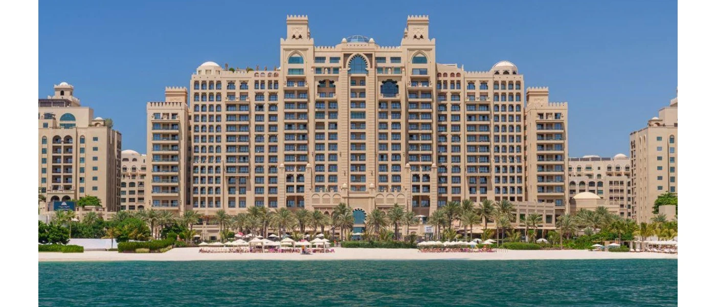 Palatial-looking sand-coloured exterior of Fairmont The Palm, on a white-sand beach right on the Dubai waterfront