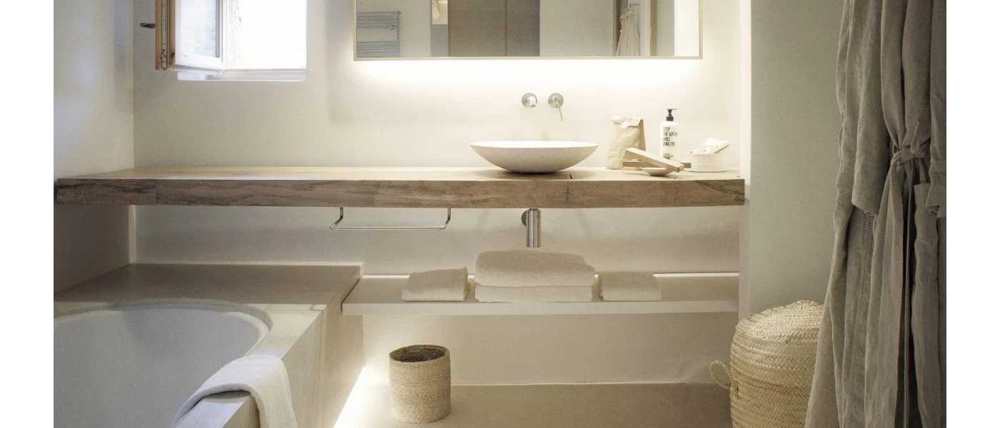 Neutral bathroom with white and wooden furnishings, a standalone sink and bathrobe hanging up