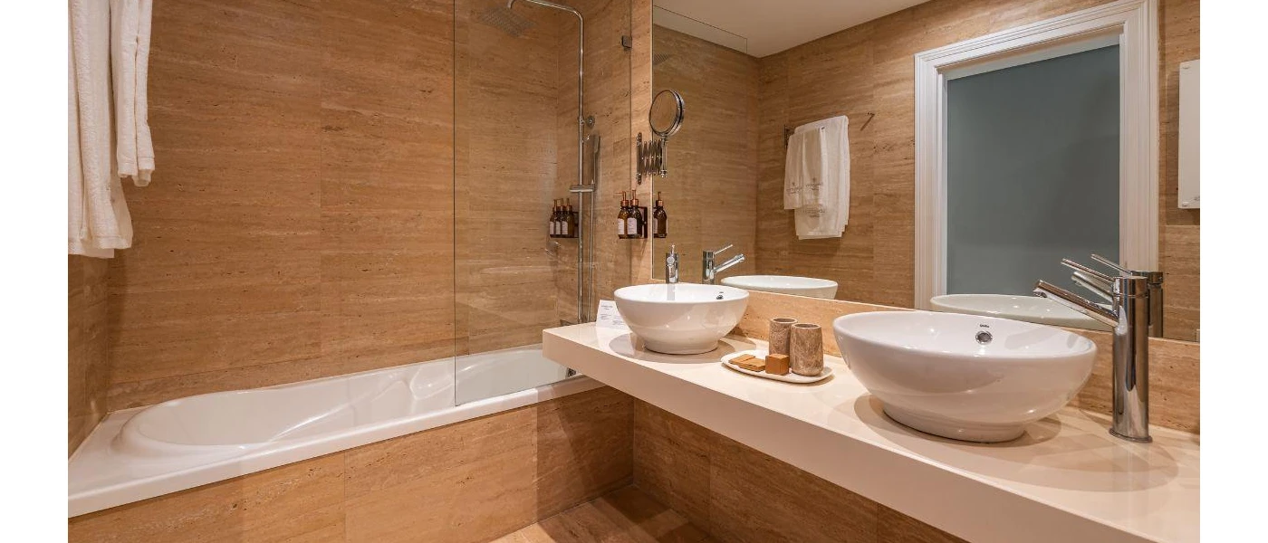 Modern bathroom with caramel-coloured walls, a large vanity unit with his and hers sinks and a frosted window