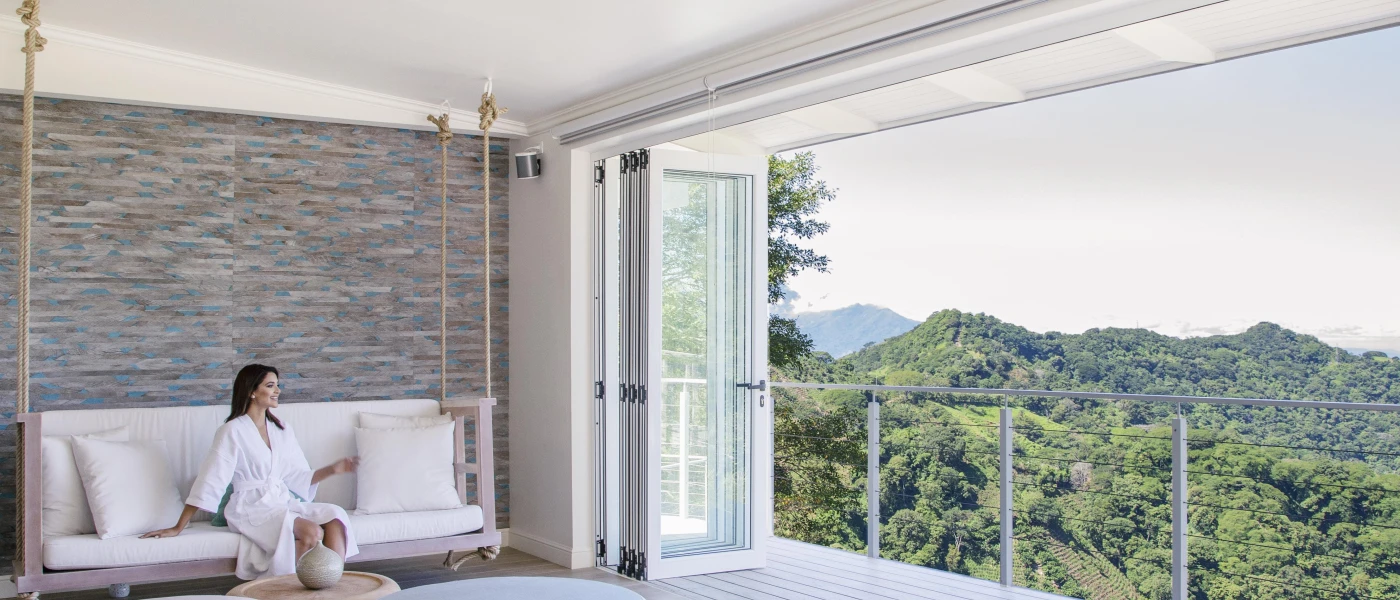 Woman in a robe relaxing while enjoying the view of surrounding mountains