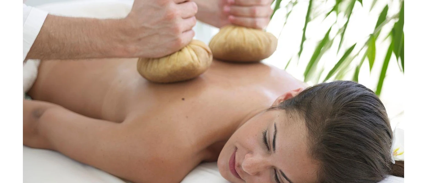 Woman lies on her front as a therapist carries out a treatment on her back