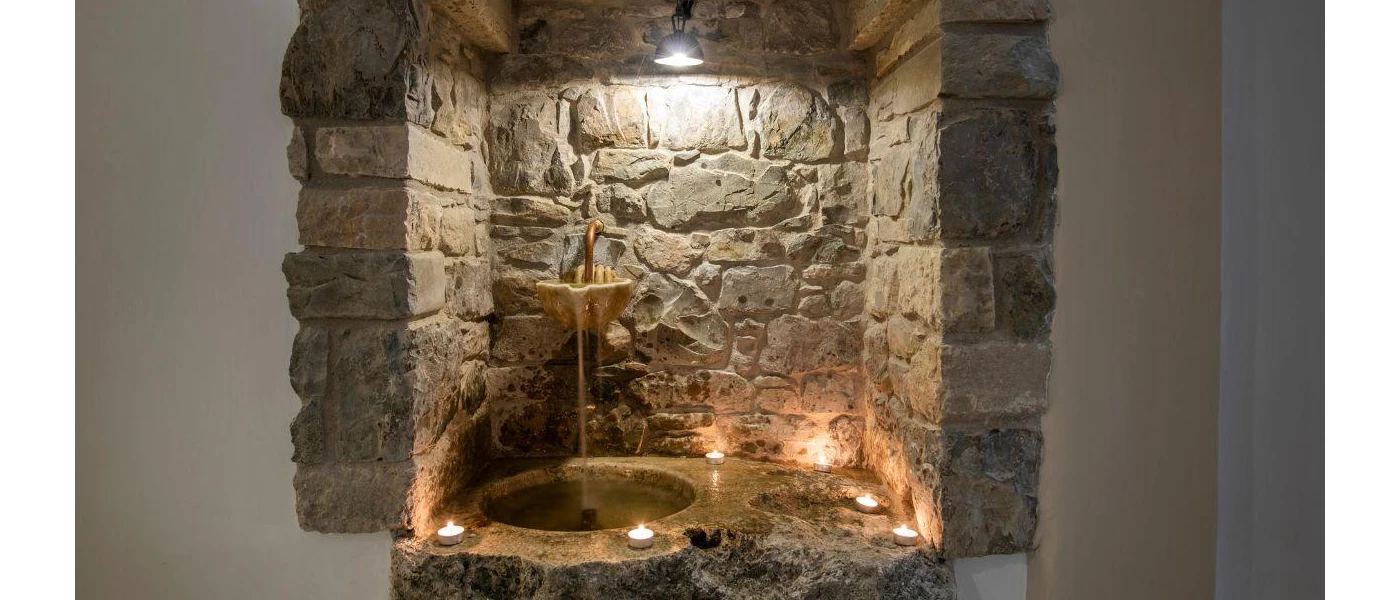 Stone water fountain lit by candles