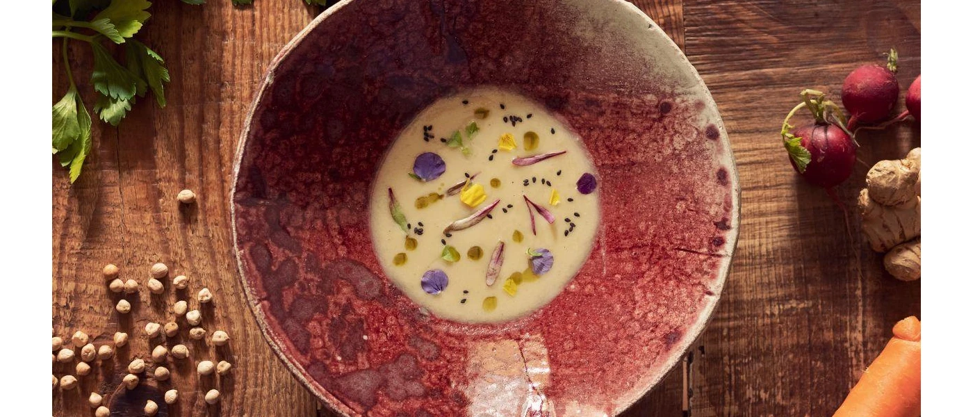 Pink bowl with creamy liquid with edible flowers