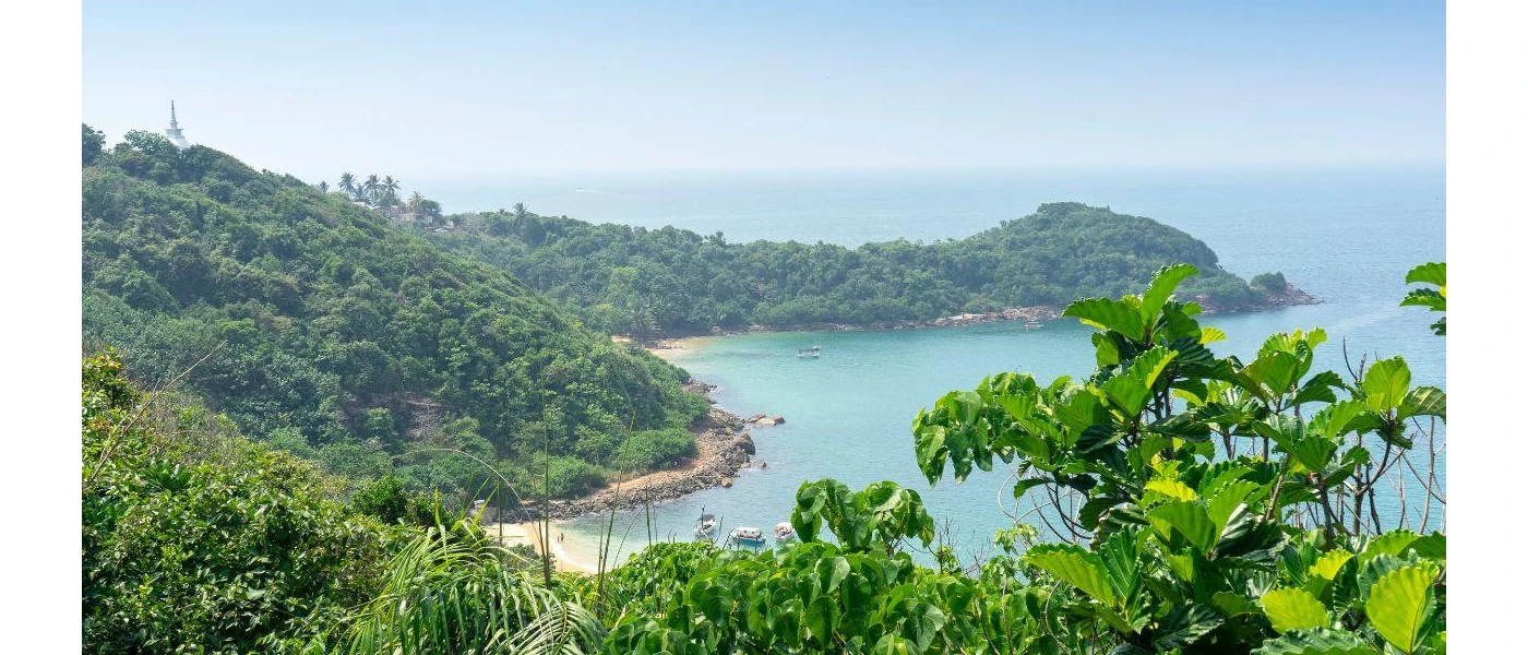 Jungle-cloaked hills overlooking the ocean and a golden sandy beach