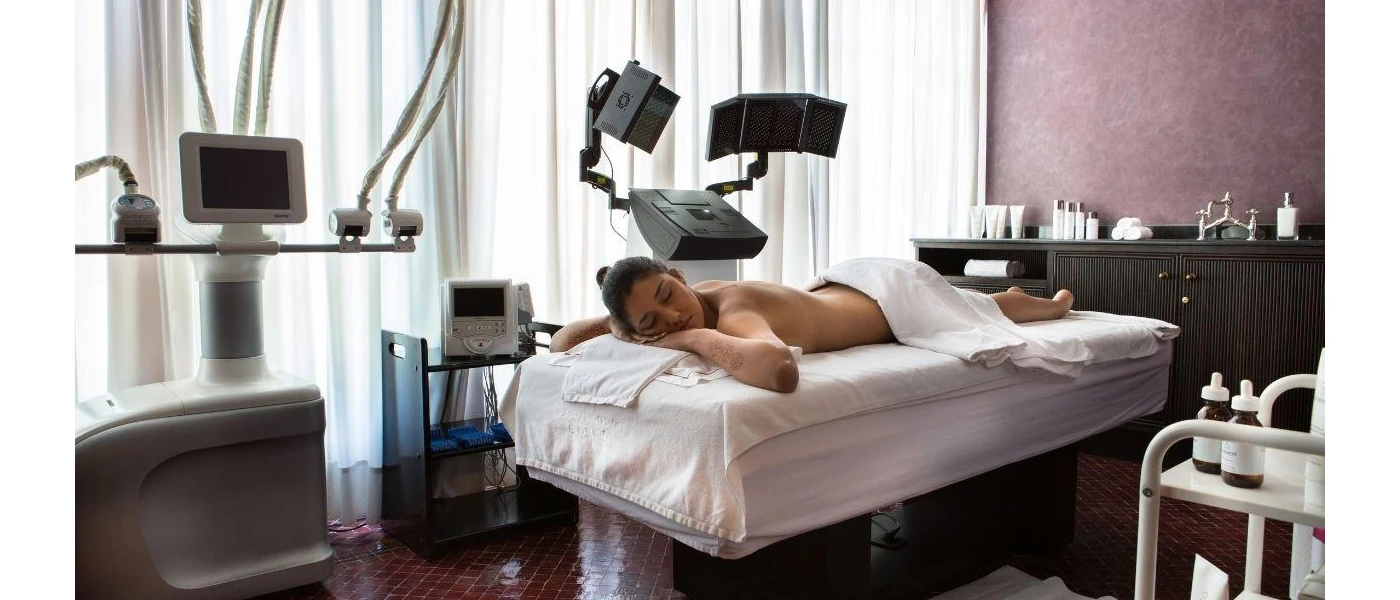 Woman lying on a bed relaxing in a towel surrounded by medical equipment 