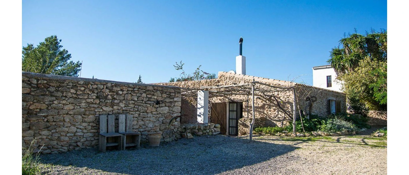 Villa with cobbled stone walls surrounded by greenery