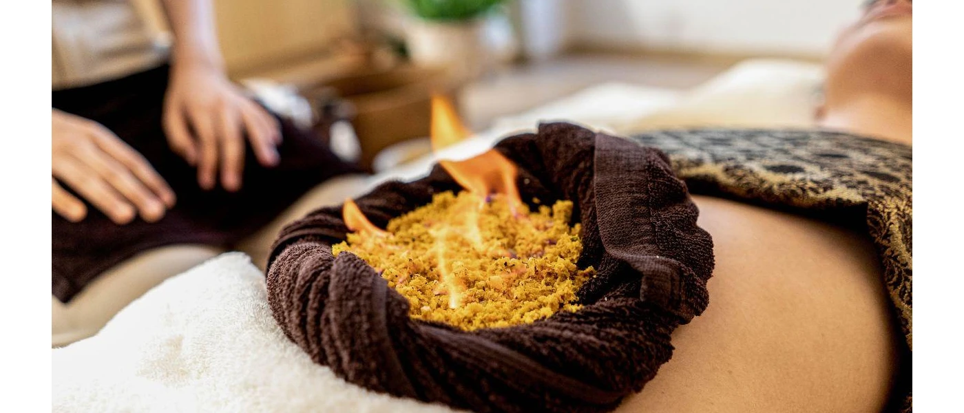 Person has herbs burned on their stomach in a cleansing ritual 